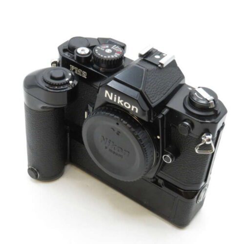 A black Nikon film camera with a vertical grip attachment, featuring manual controls and a prominent brand logo.