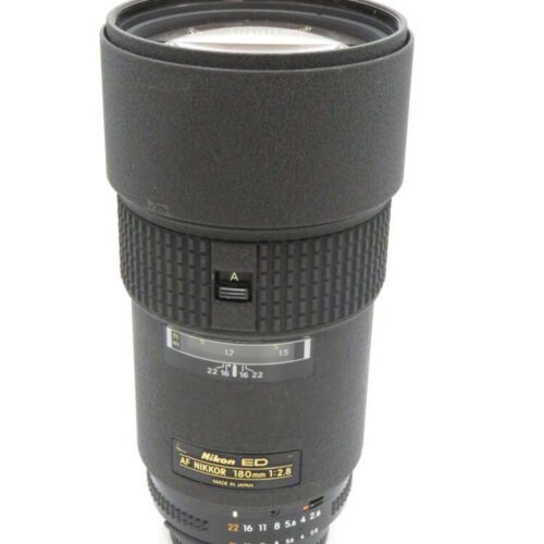 A Nikon AF Nikkor 180mm f/2.8 camera lens with a textured exterior and various control dials.