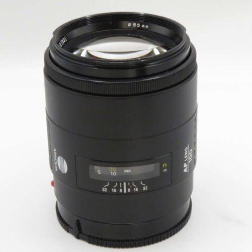 Close-up of a black camera lens with a focus ring, aperture markings, and "AF 100" printed on the side.