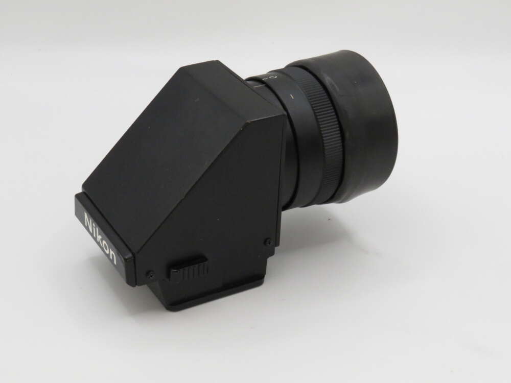 IMG_3693 A black Nikon camera viewfinder with a rectangular body and a cylindrical attachment, set against a plain background.