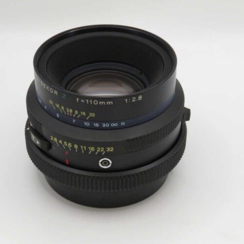 A black camera lens with a focal length of 110mm and an aperture of f/2.8, featuring distance and aperture markings.