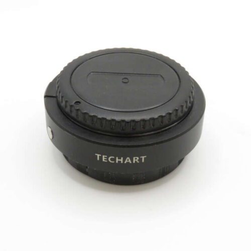 A black Techart camera lens adapter with a focus ring, viewed against a plain white background.