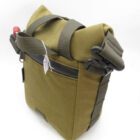 A green canvas shoulder bag with a roll-top closure and adjustable dark green straps, featuring a zippered front pocket.