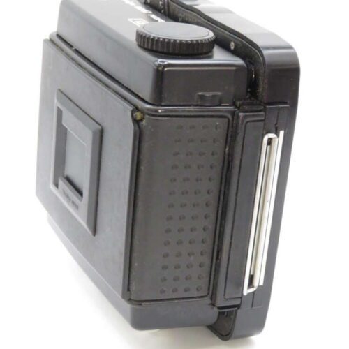 A vintage black instant camera with a textured grip and folding design.