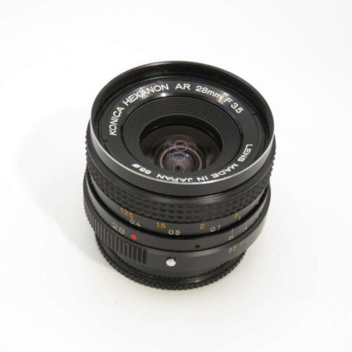 Konica Hexanon AR 28mm f3.5 camera lens with visible aperture and focus rings, set against a white background.