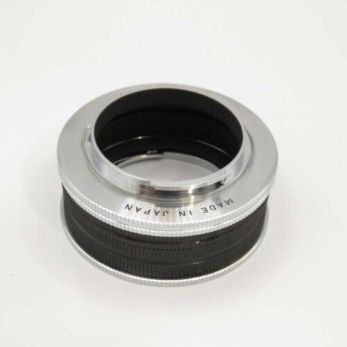 A camera lens adapter with "Made in Japan" engraved on the silver rim, featuring a black inner ring.