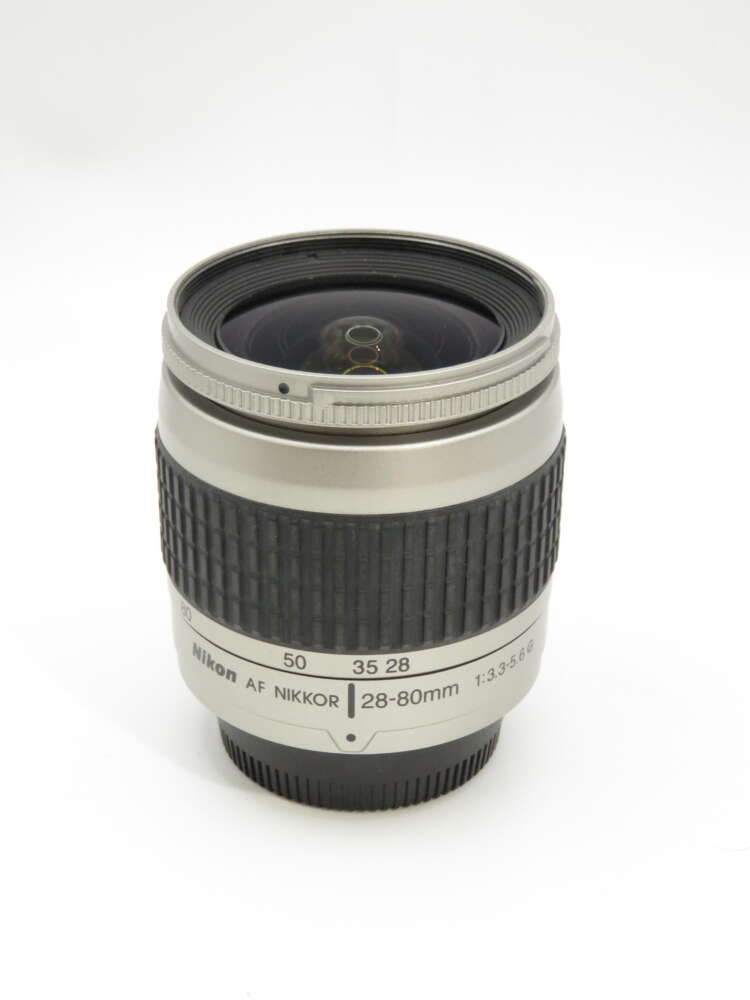 IMG_3855 A Nikkor 28-80mm camera lens with a textured grip and clear markings for focus and zoom ranges.