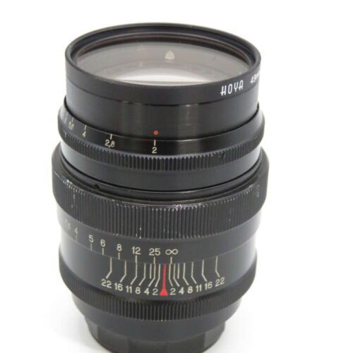 A vintage Hoya camera lens with focus and aperture settings visible on a white background.