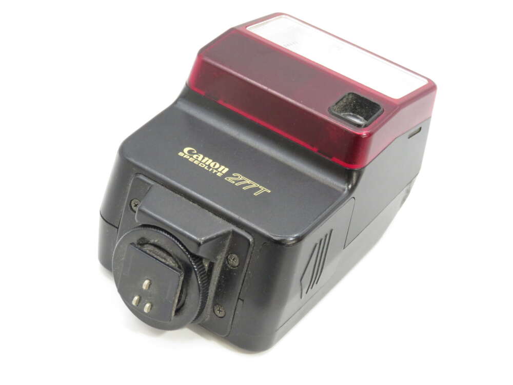 IMG_3876 Canon Speedlite 277T flash unit with a red translucent cover and a mounting base.
