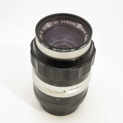 A vintage camera lens with visible text "SkyLight 1B" and "Nippon Kogaku," featuring a black and silver design.