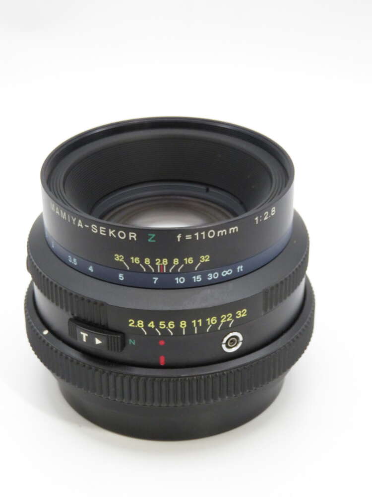 IMG_3904 A Mamiya-Sekor camera lens with focal length 110mm and aperture 1:2.8, marked with a focus scale and depth of field indicators.