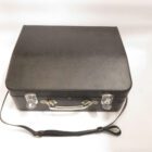 A black leather briefcase with metal clasps, a handle, and an adjustable shoulder strap.