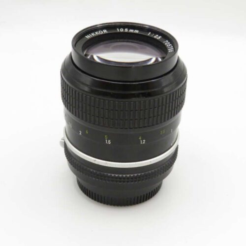A Nikon Nikkor 105mm f/2.5 camera lens with aperture and focus rings visible.