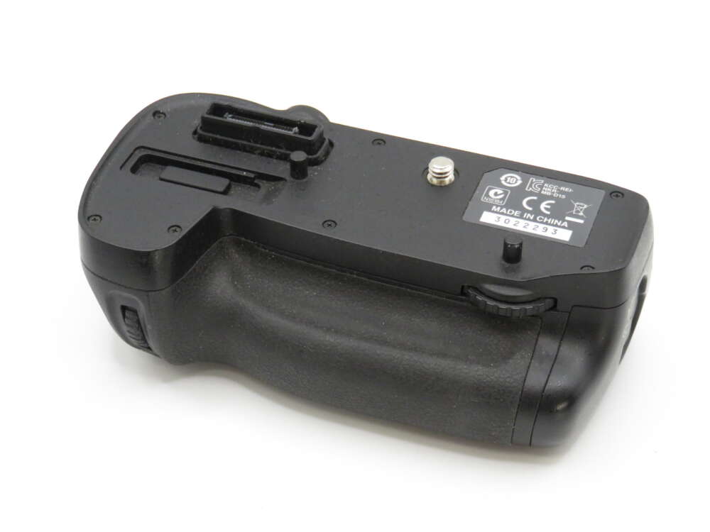 IMG_3958 Camera battery grip with rubberised texture, control dials, and a visible label stating "Made in China."