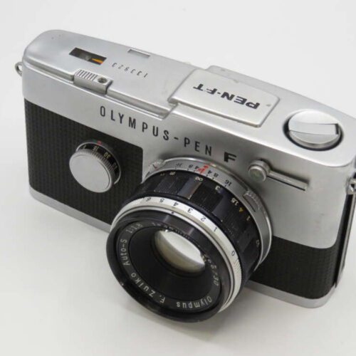 A vintage Olympus Pen F 35mm film camera with a silver body and a black textured grip.