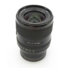 A camera lens with "FE 1.4/35 GM" markings, featuring a textured focus ring and a visible aperture scale.