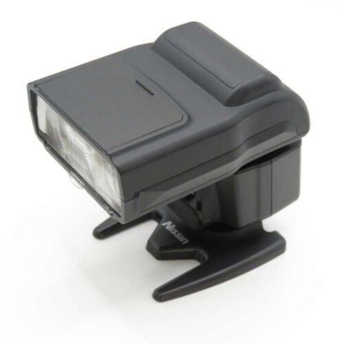 A compact camera flash unit with dual flash heads, on a small black stand.