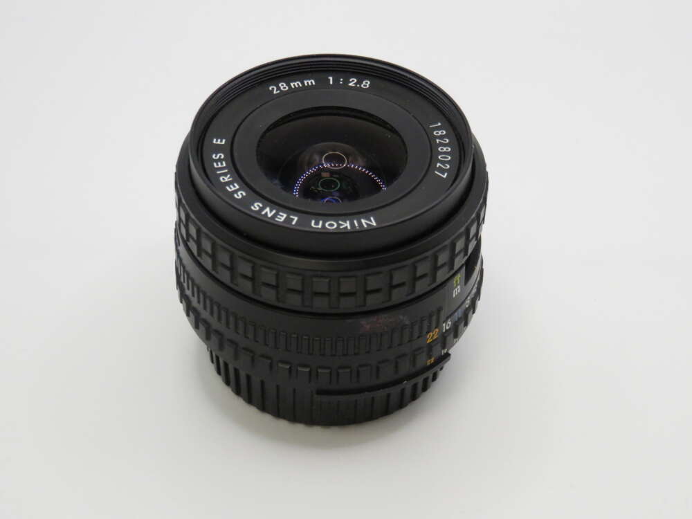 IMG_4014 A Nikon lens marked "28mm 1:2.8 Series E" with aperture and focus rings visible.