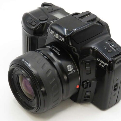 A black Minolta Dynax 3xi camera with a 35-80mm lens, displaying various buttons and grips.