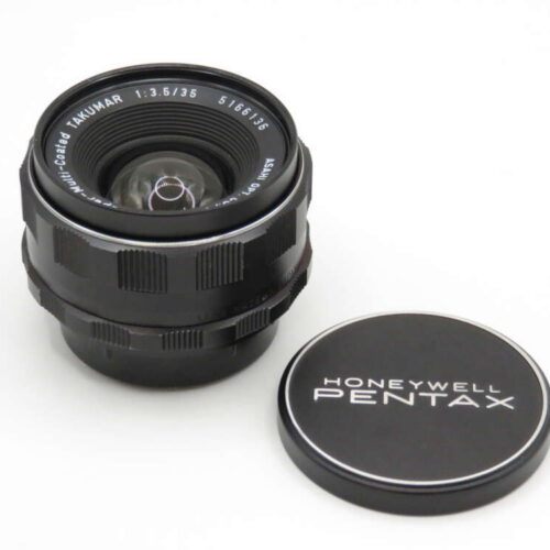 A Honeywell Pentax 35mm camera lens with a black cap displaying the brand name.