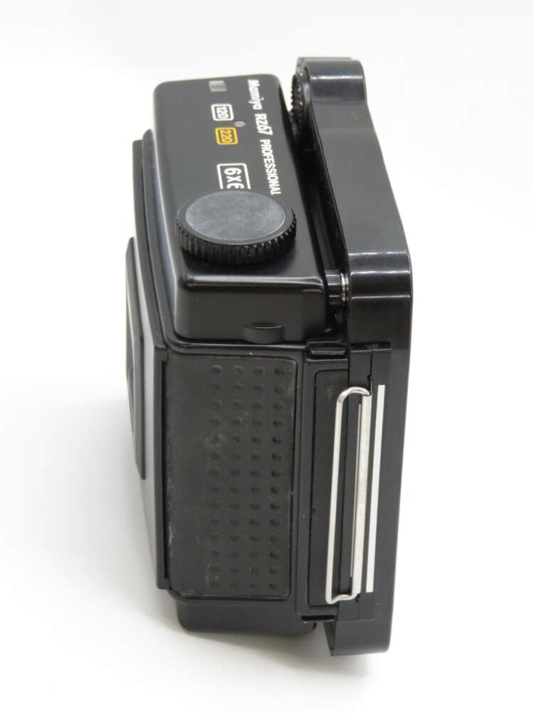 IMG_4060 Side view of a black compact digital camera with visible dials and buttons.
