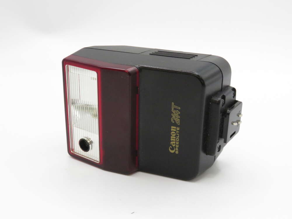 IMG_4077 A Canon Speedlite 244T camera flash with a black body and clear red lens, shown on a white background.