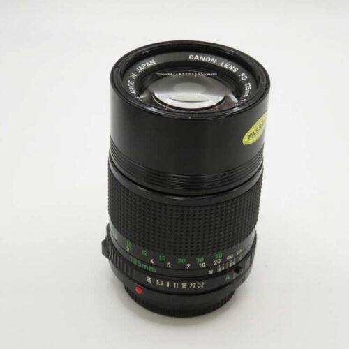 A black Canon telephoto lens with a 70-210 mm focal length, featuring various control markings in green and white.