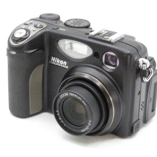 A black Nikon COOLPIX P5000 digital camera with a protruding lens and visible control buttons and dials.
