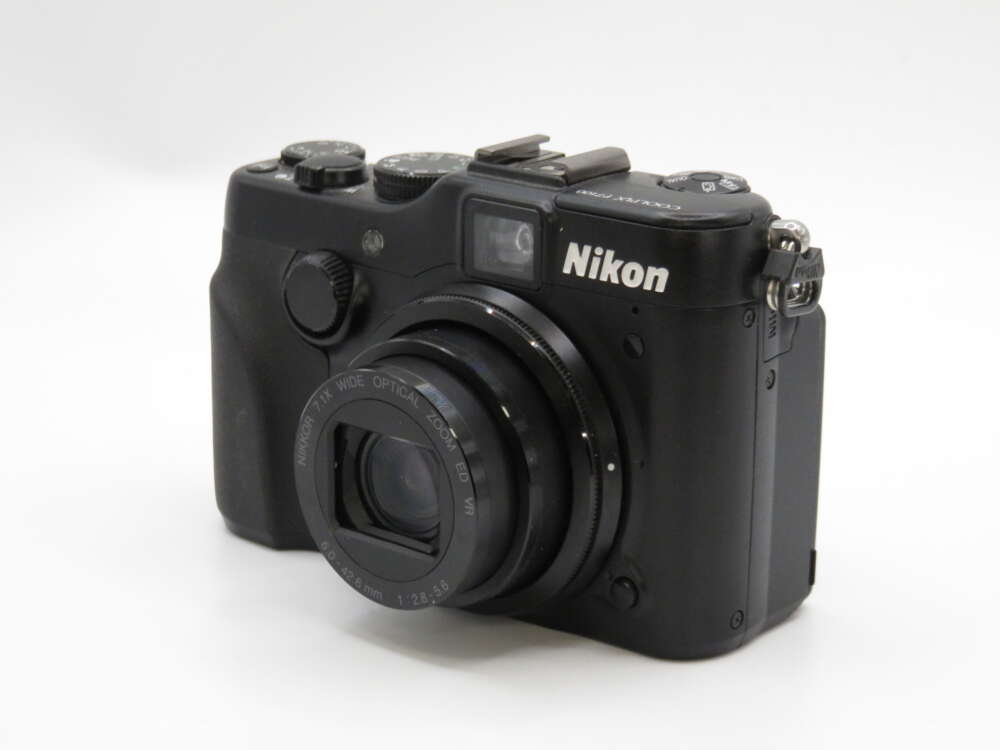 IMG_4168 A black Nikon Coolpix camera with a lens extended, buttons, and dials visible on top.