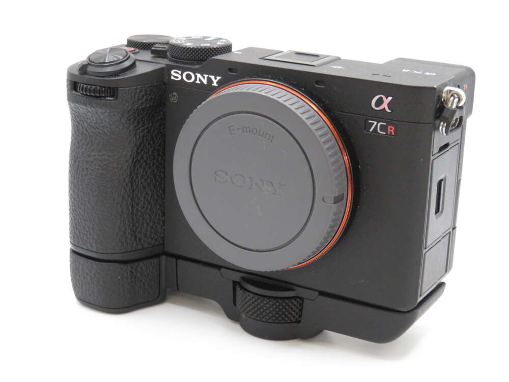 IMG_4204 A black Sony α7CR camera with a textured grip and lens cap, featuring prominent brand and model markings.