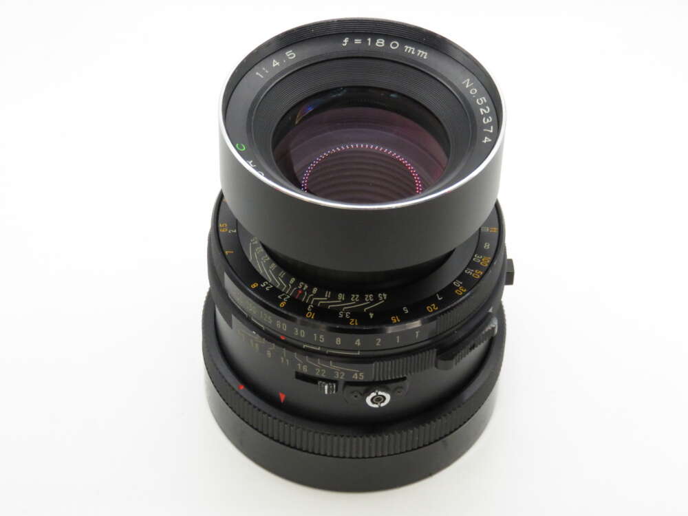 IMG_4214 A black camera lens with a 180mm focal length and various dials and markings on its body.