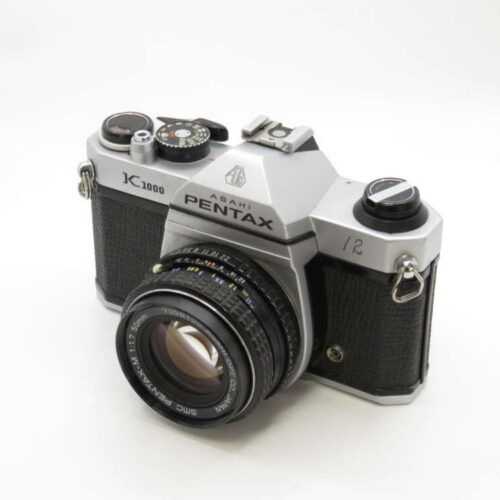 A vintage Asahi Pentax K1000 film camera with a black and silver body and a detailed lens.