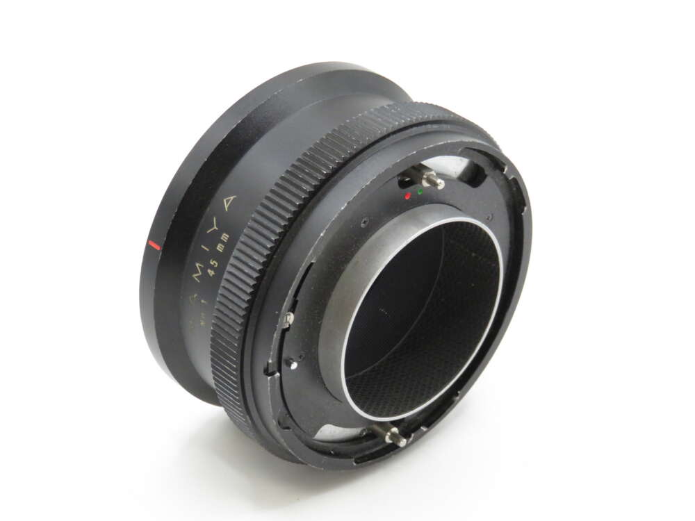 IMG_4255 A black camera lens adapter with the text "Mamiya 645 mm" displayed on its side.