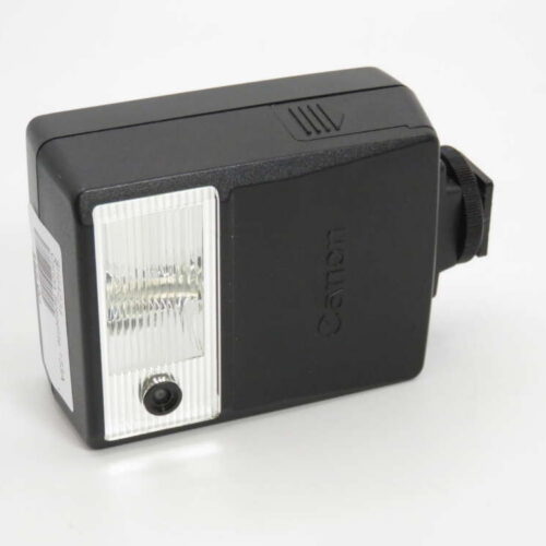 A black Canon camera flash unit with a front light panel and a connector on the side.