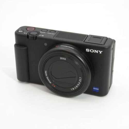 A black Sony compact digital camera with a large lens and various control buttons on top.