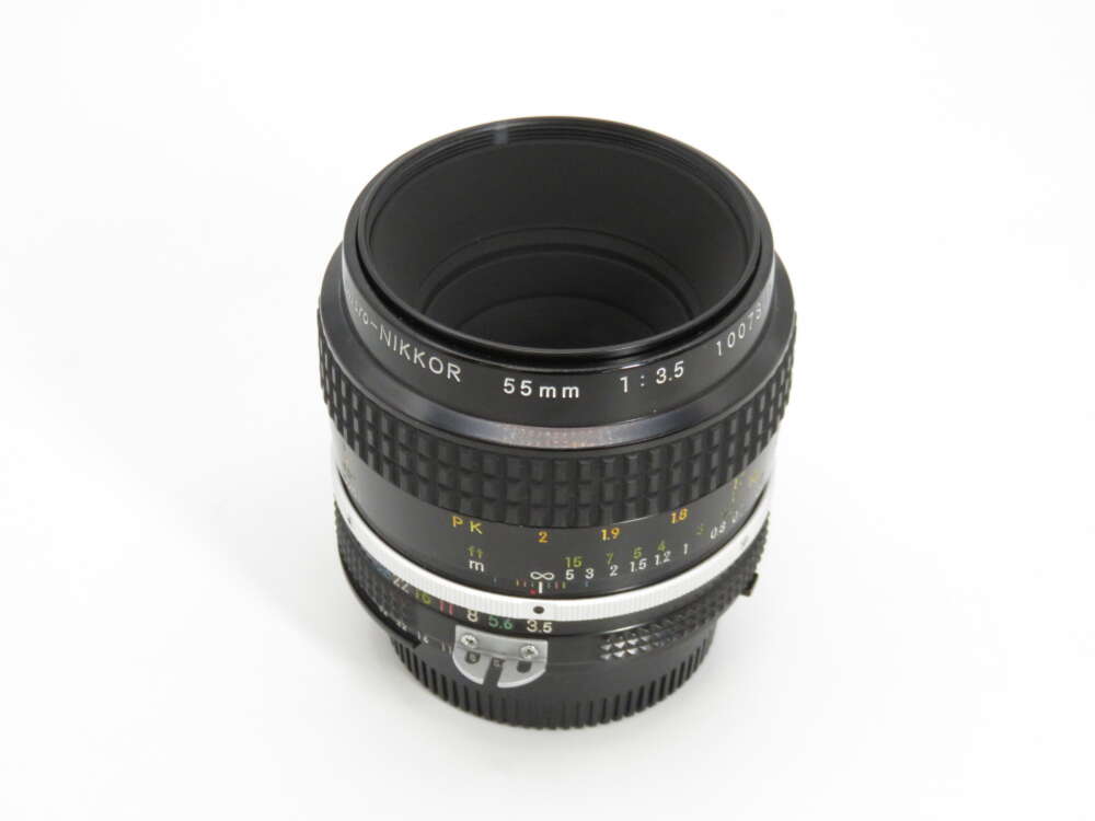 IMG_4308 A vintage Nikkor 55mm f/3.5 camera lens with textured grip and aperture markings.