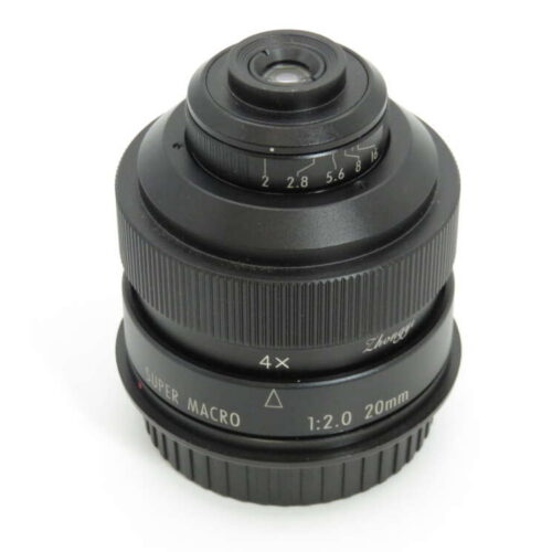 A black camera lens with visible markings, including "Super Macro 1:2.0 20mm" and a focusing ring with aperture settings.