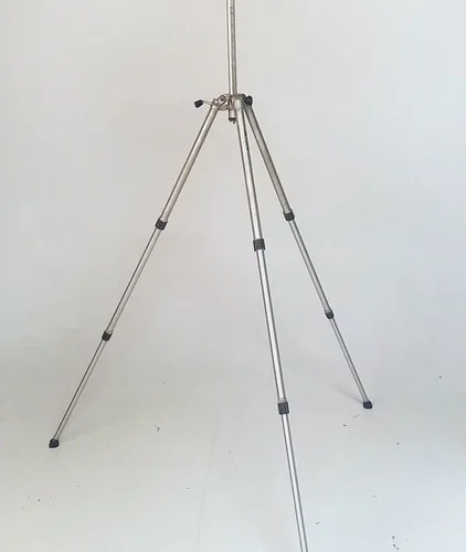Silver tripod with adjustable legs and a mounting head, set against a plain white background.